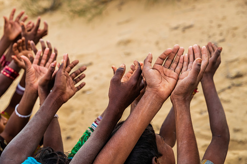 Poor Indian children keeping their hands up and asking for support. Many Indian children suffer from poverty - more than 50% of India's total population  lives below the poverty line, and more than 40% of this population are children.