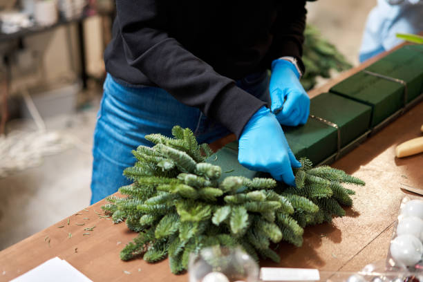 istock A woman decorates a Christmas arrangement. Master class on making decorative ornaments. Christmas decor with their own hands. The new year celebration. Flower shop 1223582788