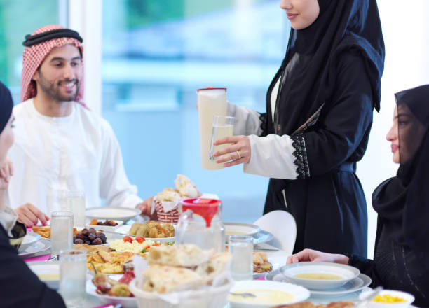 istock Muslim family having Iftar dinner drinking water to break feast 1223586157