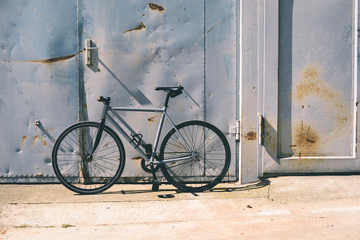 Vintage bicycle on old rustic dirty wall house, many stain on wood wall. Classic bike old bicycle on decay brick wall retro style. Retro styled image of an old bike.