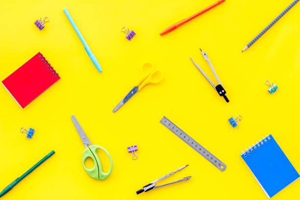 istock Flat lay stationery set - notebook, pen, sciccors - on yellow background top view 1223590475