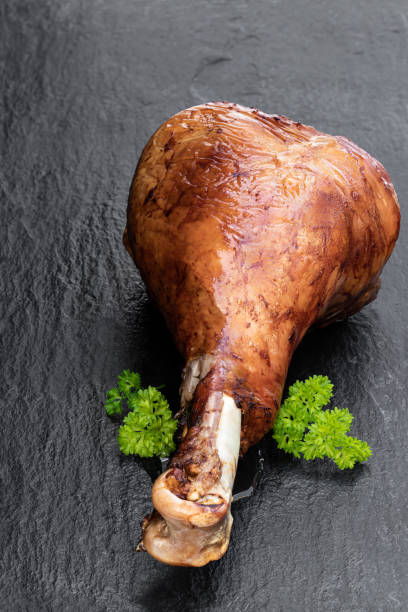 Roasted turkey leg on black stone background