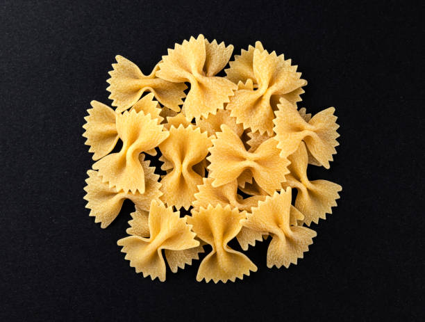 istock Raw farfalle pasta isolated on black background, top view 1223592673