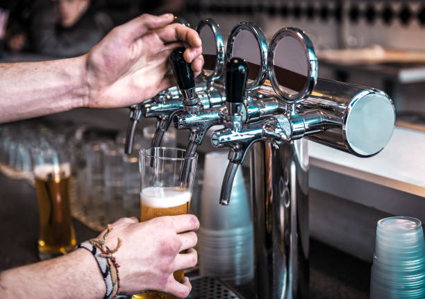 istock the bartender pours beer into a glass 1223594184