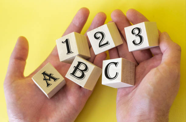 istock Hands holding cubes on a yellow background with the text 1 2 3 A B C 1223594381