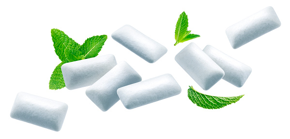 Falling pads of bubble gum with green mint leaves, chewing gums with spearmint flavour isolated on white background