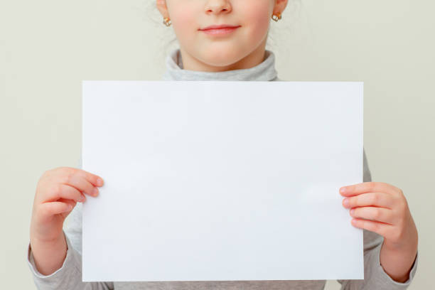 istock Mockup sheet of paper in child's hands. 1223597428