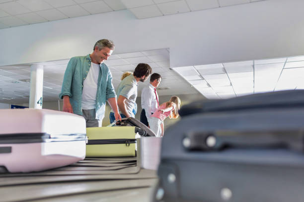 istock Man getting his suitcase on baggage claiming area in airport 1223601985