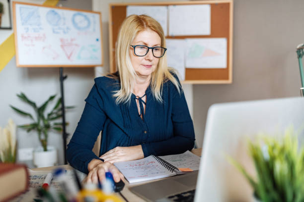 istock Professor at home, looking and talking on web video meeting with students 1223604201