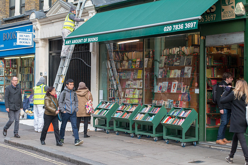 This second-hand bookseller sells and purchases rare and antiquarian books and operates from its Charing Cross branch. Pedestrians walk past and maintenance workers use a ladder.