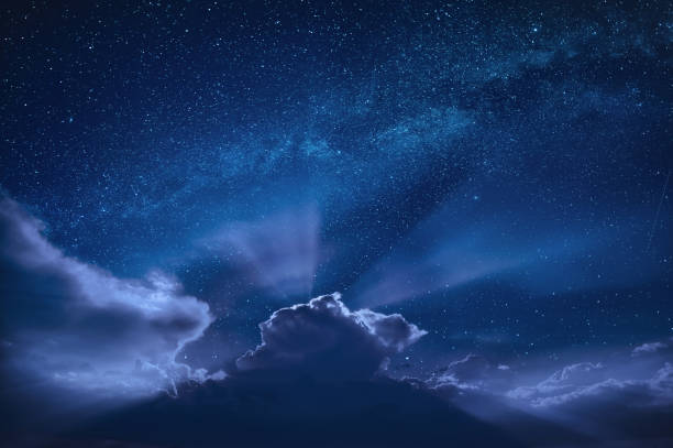 istock Beautiful moon beams in a night starry sky over dramatic clouds 1223605531