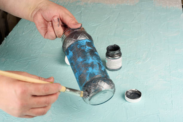 istock Coloring a glass jar with gray acrylic paint. 1223605621