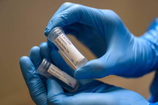 istock Laborant in protective gloves holding Coronavirus vaccine for Covid-19 1223606093