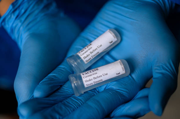 istock Laborant in protective gloves holding Coronavirus vaccine for Covid-19 1223606099