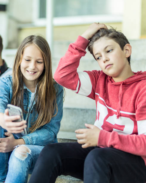 istock Two young teenagers using phone on the street 1223607071