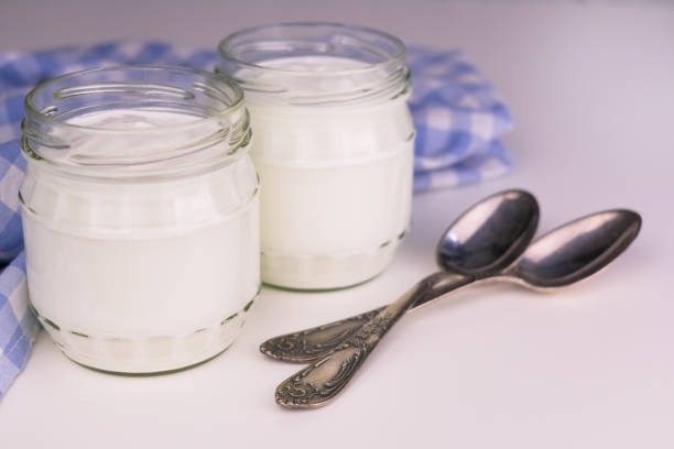 istock Two jars of Greek yogurt on a white table. Close-up. 1223608113