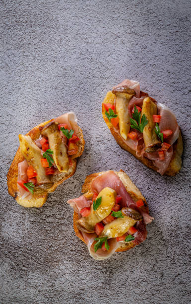 istock Bruschetta with proscuitto ham, tomatoes and king oyster mushroom. 1223610004