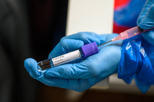 istock Hand in protective gloves fill syringe with Coronavirus vaccine for Covid-19 immunization 1223611568