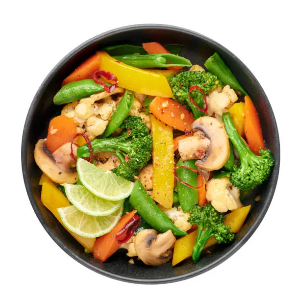 Pad Pak Ruam or Veg Thai Stir-Fried Vegetables in black bowl isolated on backdrop. Pad Pak is thailand cuisine vegetarian dish with mix of vegetables and sauces. Thai Food. Top view