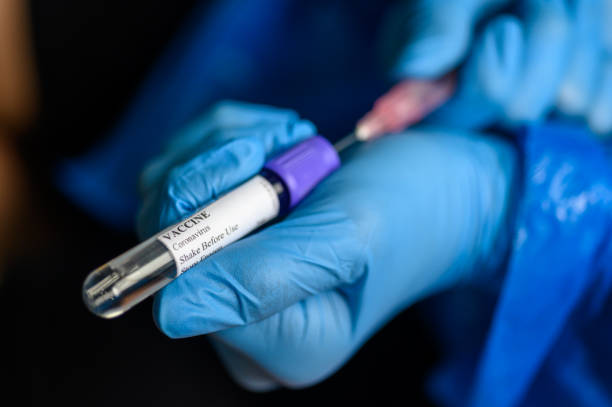 istock Hand in protective gloves fill syringe with Coronavirus vaccine for Covid-19 immunization 1223612263