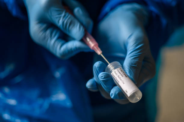 istock Hand in protective gloves fill syringe with Coronavirus vaccine for Covid-19 immunization 1223612403
