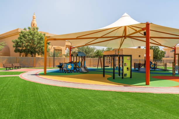 istock Small public parks in front of the Mosque equipped with the modern play structures surrounded by artificial turf and covered with the shade canopy 1223612610