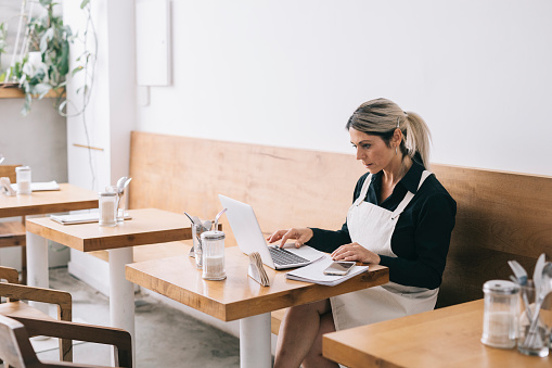 Cafe Manager Notebook Cafe Manager Working With Laptop Stock Photo - Download Image Now ...