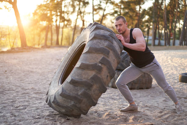 istock Strong man training workout lifting large tire outdoor DIY gym. 1223616933