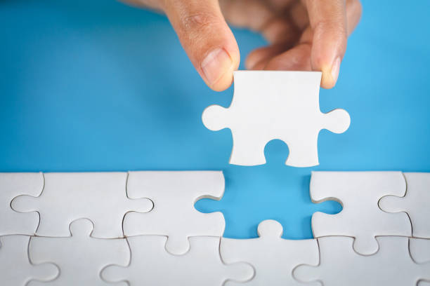 istock Hand put the last piece of jigsaw puzzle to complete the mission. Completing final task, missing jigsaw puzzle pieces and business concept with a puzzle piece missing. 1223616998