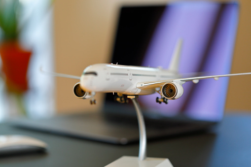 Airplane model and laptop on a table in a living room.