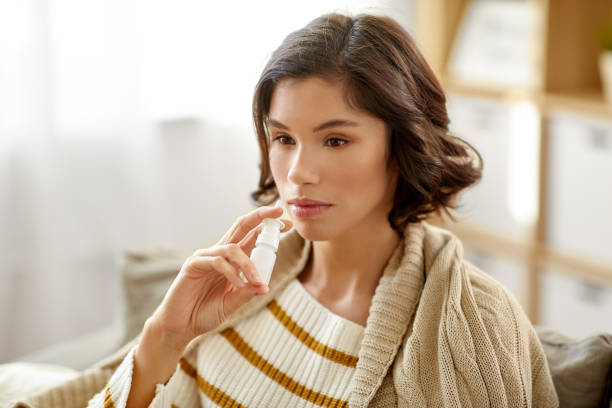 istock sick woman using nasal spray at home 1223622917