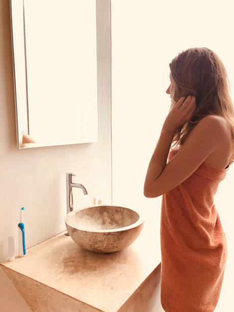 istock Young woman looking at the mirror in bathroom. 1223623818