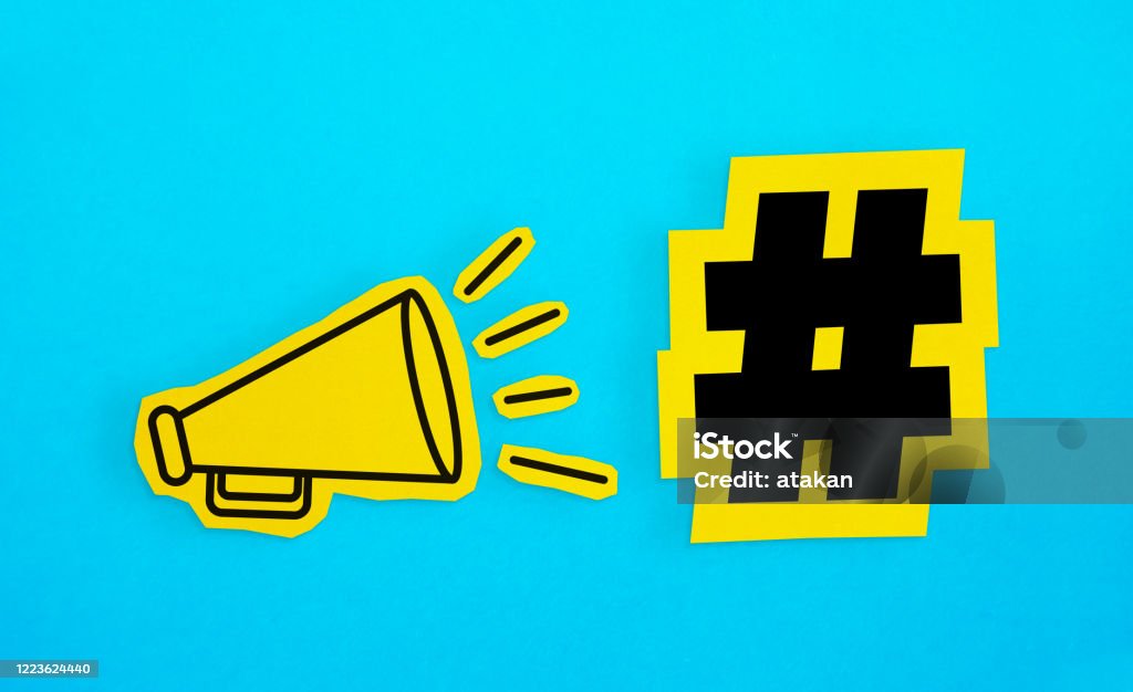 Megaphone drawing on the cut yellow paper makes “Hashtag icon” announcement. Megaphone drawing on the cut yellow paper makes “Hashtag icon” announcement. Horizontal composition with copy space. Communication Concept. Hashtag Stock Photo