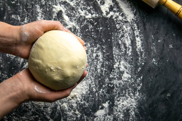 strong woman's hands knead the dough on dark background. top views with clear space - gourmet pastry bread horizontal imagens e fotografias de stock