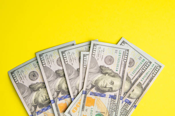 istock One hundred dollar banknotes on colored background top view, with empty place for your text business money concept, US dollar money cash on yellow background 1223629467