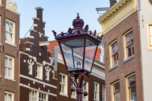 Street light on a street in Amsterdam with canal houses in background