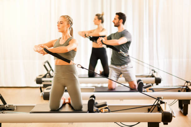 istock Group of people doing pilates torsion rotation exercises 1223631319