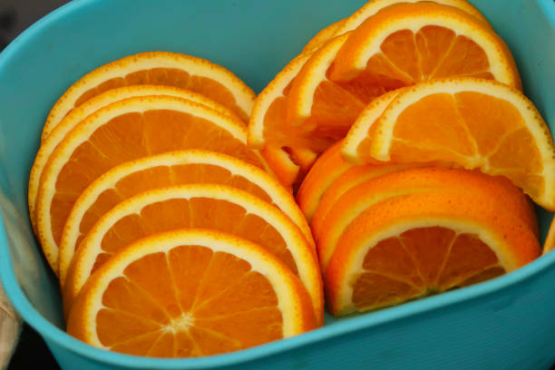Stock photo showing a pile of orange half slices sliced ready for use in cocktails and alcoholic drinks at a bar.