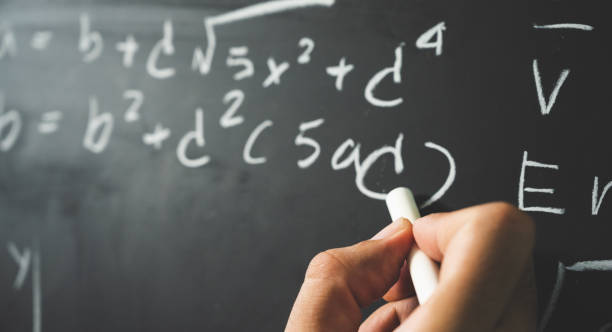 istock Education background concept. Close up male hand writing mathematical formula on chalkboard. 1223635225