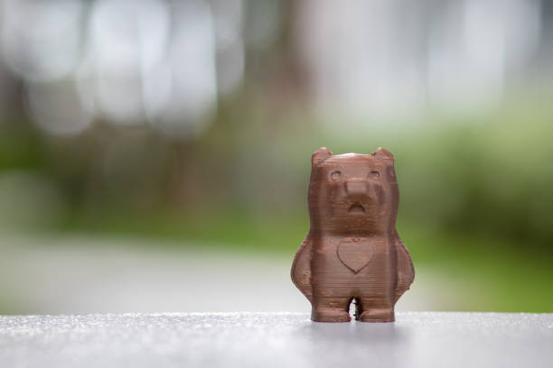 istock Cute teddy brown bear model with copy space. Created from a 3d printer. Placed on a desk and a green natural background. 1223635789
