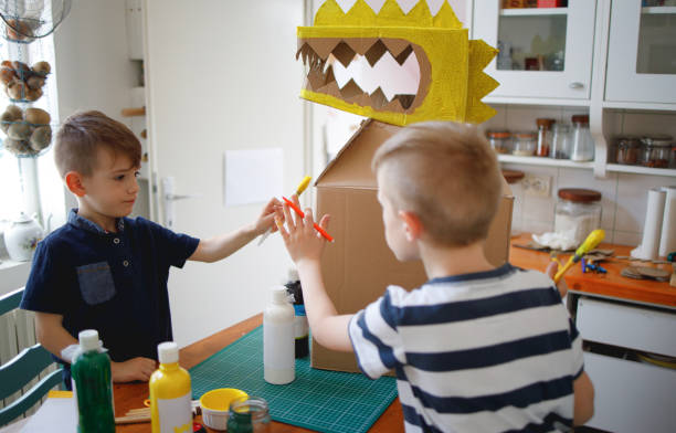 istock Brothers painting a cardboard dinosaur costume 1223636418
