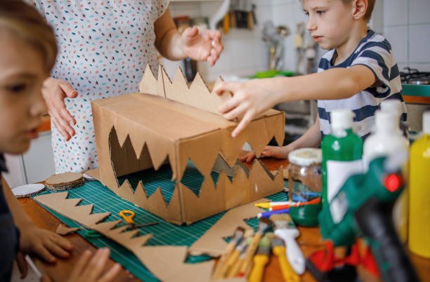 istock Mom and kids making a cardboard dinosaur costume 1223637033