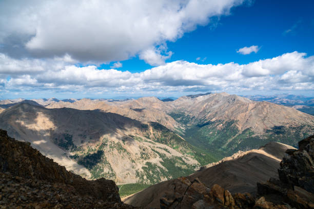 Sawatch Mountain Range Summer Rocky Mountains of Colorado view from the Summit of Mount Elbert Sunny afternoon with blue sky and a few puffy clouds deep valley and vast forests