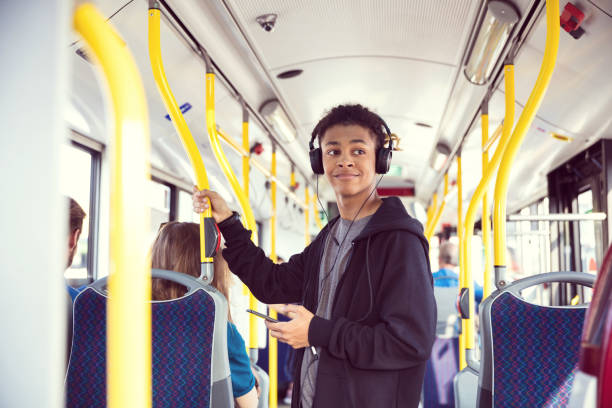 ragazzo con cellulare in viaggio in autobus - transportation bus mode of transport public transportation foto e immagini stock