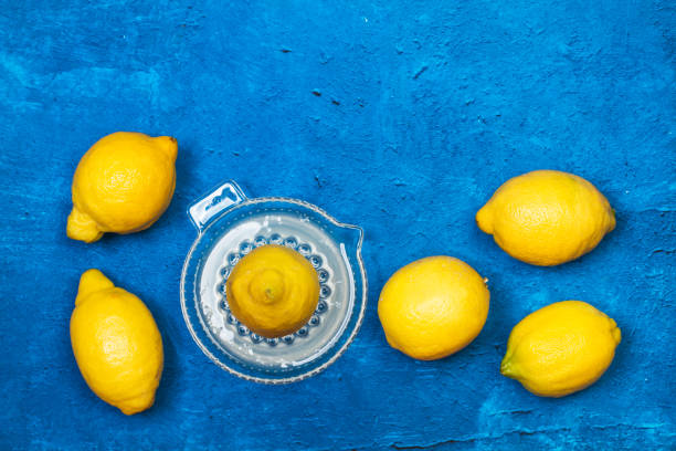 istock Lemons and a citrus squeezer on a textured classic blue background 1223640542