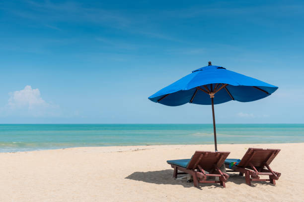 Beach bench under the umbrella on tropical island beach