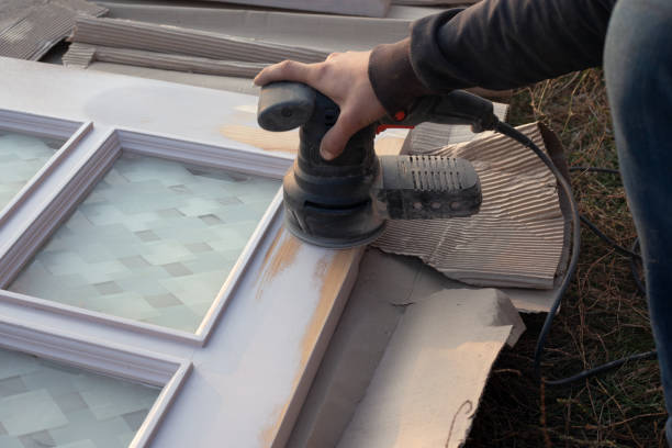 istock master processes wooden doors with a grinding tool, restoration, preparing the door for painting, wood surface cleaning 1223650459