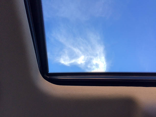 istock blue sky with white cloud abstract through car sunroof 1223654014