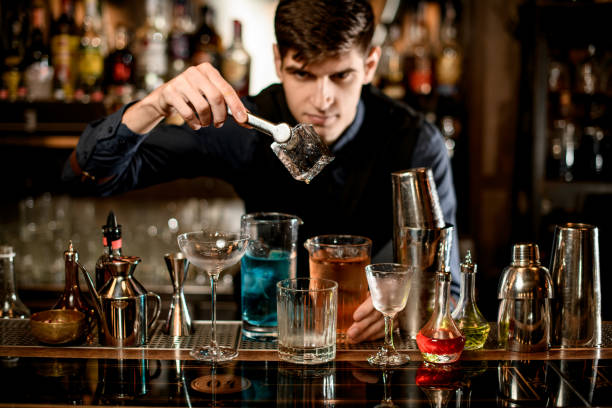 istock bartender holds by forceps big ice cube over a glass at the bar. 1223654091