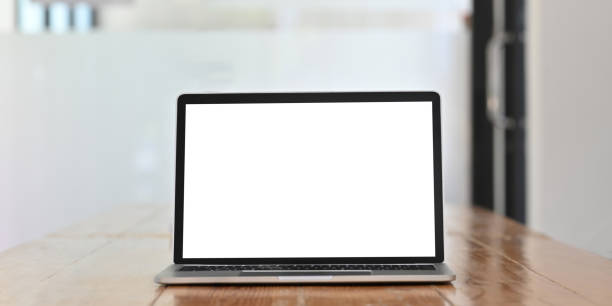 istock White blank screen computer laptop putting on wooden working desk over comfortable office glass wall as background. 1223655190